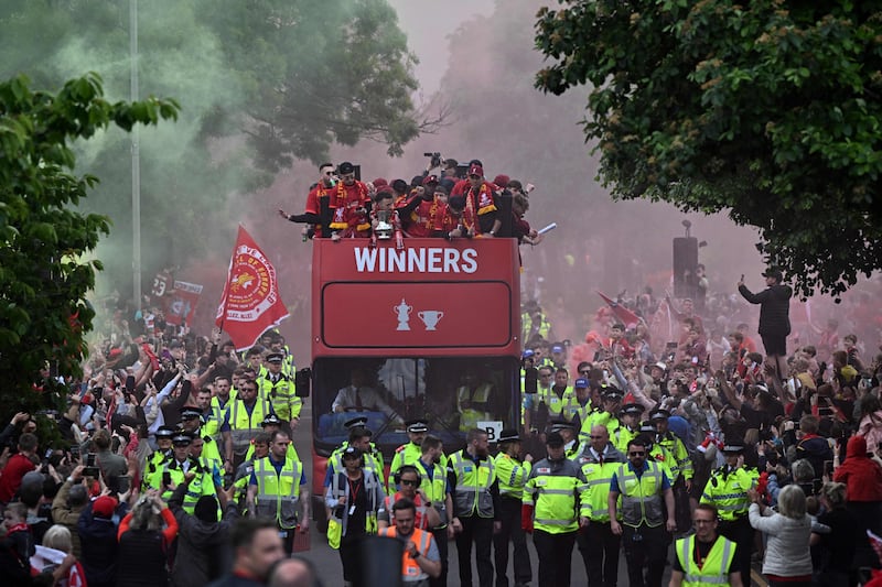 Reds players wave from an open-top bus during a parade through the streets of Liverpool. AFP
