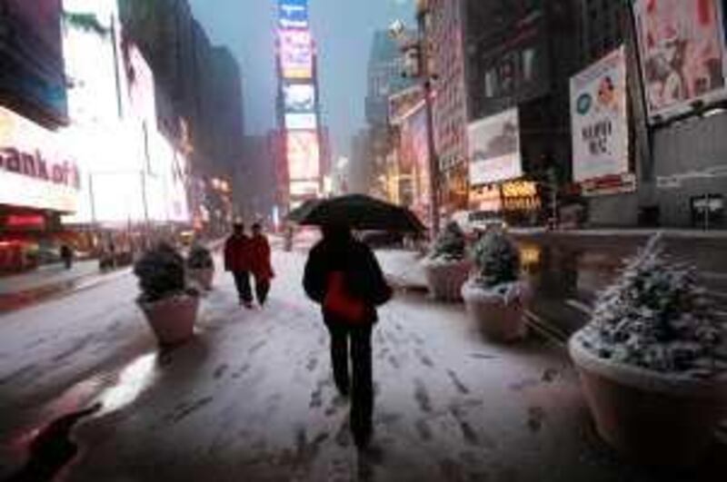 Early morning pedestrians walk in New York's Times Square, Wednesday, Feb. 10, 2010. A blizzard is expected to drop 10 to 15 inches (25 to 38 cm) of snow on the metropolitan area Wednesday. (AP Photo/Mark Lennihan)