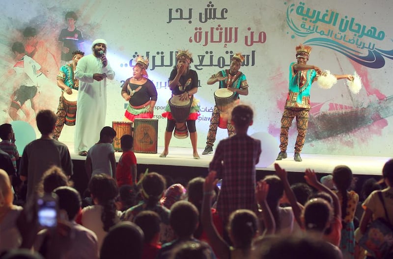 Visitors watch a drumming performance at the Al Gharbia Watersports Festival.