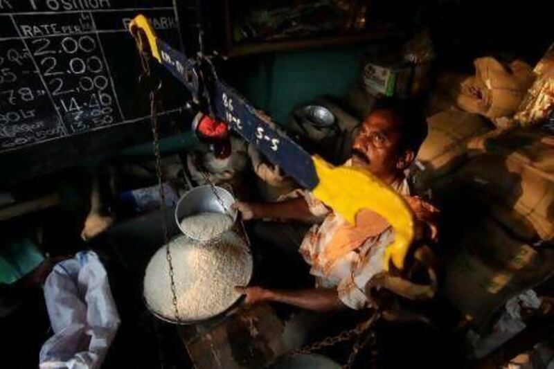 A shopkeeper weighs rice under India's Public Distribution System, which provides subsidised food to those living under the poverty line. But the scheme has been plagued by corruption, such as ration cards being given out under false names and duplicate cards being held by families.