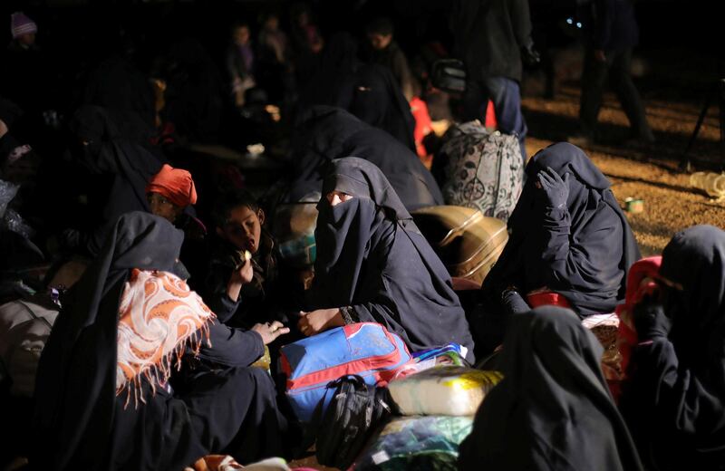 Women sit together with their belongings near the village of Baghouz, Deir Al Zor province, Syria February 25, 2019. REUTERS/Rodi Said