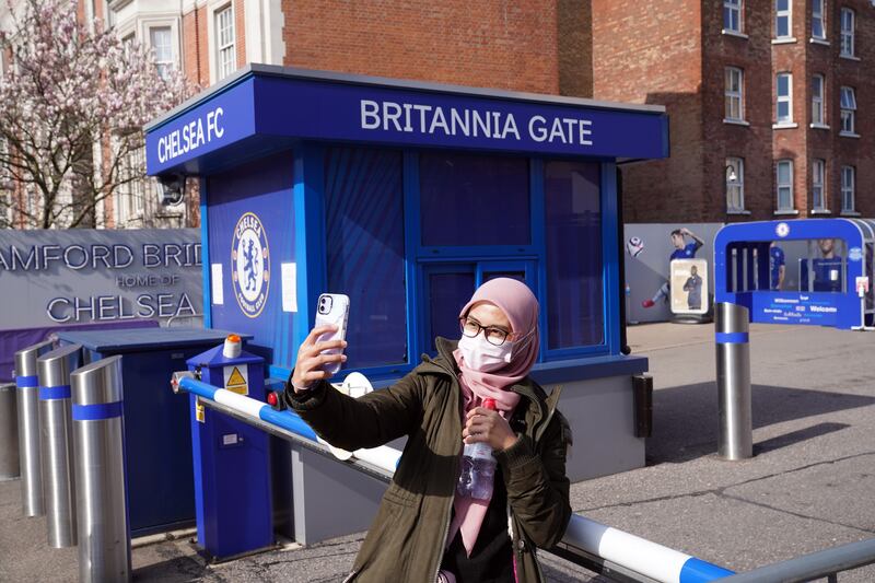 A fan takes a selfie outside of Stamford Bridge. PA