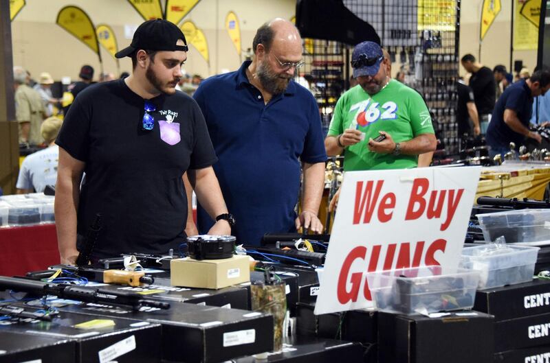 Gun enthusiasts attend the South Florida Gun Show at Dade County Youth Fairgrounds in Miami, Florida, on February 17, 2018.
The gun show started three days after a mass shooting 30 miles (48kms) away at the Marjory Douglas High School in Parkland, Florida. Vendors said they were expecting a big turnout and sales, and because of the shooting there will be a panic regarding gun restrictions and new laws that could be put in place. Vendor Domingo Martin said he brought his entire stock of of 42 AR-15's, adding that he is not the only one selling the unit at the weekend show.  / AFP PHOTO / Michele Eve Sandberg