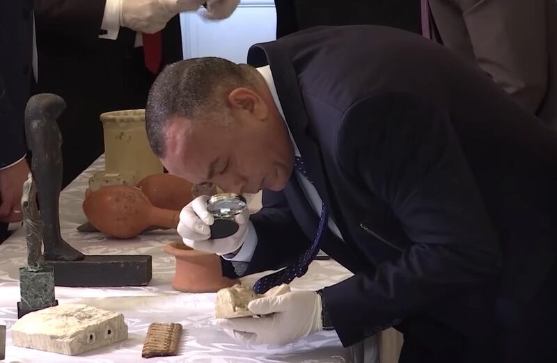 Egyptian experts and officials inspect recovered smuggled artefacts at the embassy in Paris. Screengrab