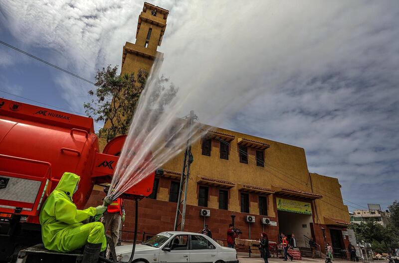 A Palestinian man sprays disinfectant as a precaution against the spread of the coronavirus in the streets of Gaza City.  EPA