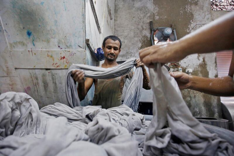 Workers dye fabrics inside a dye factory at an industrial area in Mumbai, India October 6, 2017. REUTERS/Shailesh Andrade