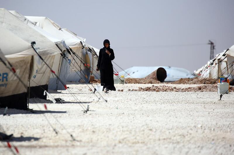 A displaced Syrian woman walks at a temporary camp in the northern Syrian village of Ain Issa, where many people who fled the ISIL stronghold of Raqqa are taking shelter. Delil Souleiman / AFP