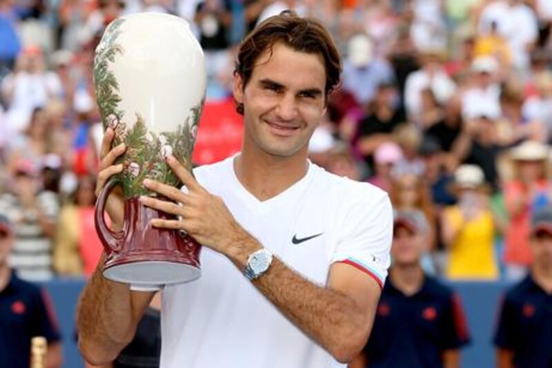 Roger Federer celebrates with the Western and Southern Open winner's trophy