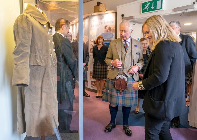 King Charles takes a look at the 'Tomintoul coat' in the Discovery Centre. Reuters