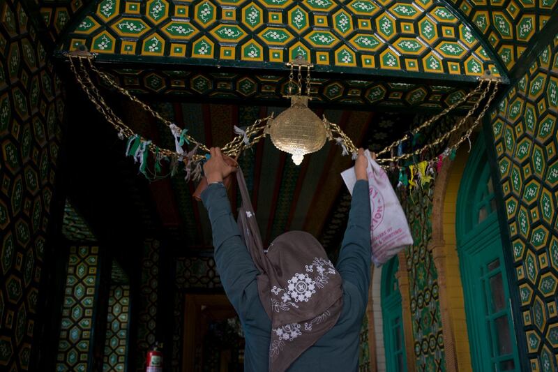 A Kashmiri woman prays at the entrance of the shrine of Sufi saint Shiekh Abdul Qadir Jeelani during the holy fasting month of Ramadan in Srinagar, Indian controlled Kashmir. AP Photo