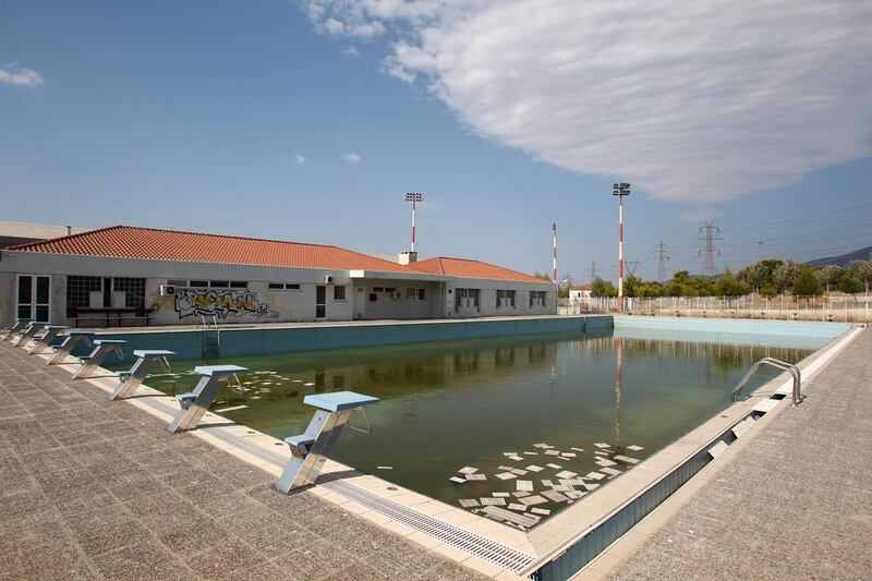 In this August 2, 2012 file photo, murky water and rubbish fill an abandoned training pool for athletes at the Olympic village on the northern fringes of Athens. The legacy of Athens’ Olympics has stirred vigorous debate, and Greek authorities have been widely criticized for not having a post-Games plan for the infrastructure. While some of the venues built specifically for the games have been converted for other uses, many are underused or abandoned, and very few provide the state with any revenue. Some critics even say that the multibillion dollar cost of the games played a modest role in the nation’s 2008 economic meltdown. Thanassis Stavrakis / AP Photo