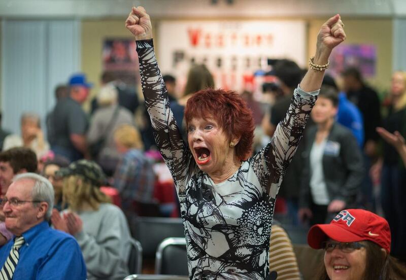 Robin Bernik, who recently moved to Oregon from Florida, watches as her home state is called for Republican presidential candidate Donald Trump at a Republican watch party at the Vet’s Club in in Eugene, Oregon. Brian Davies / The Register-Guard via AP