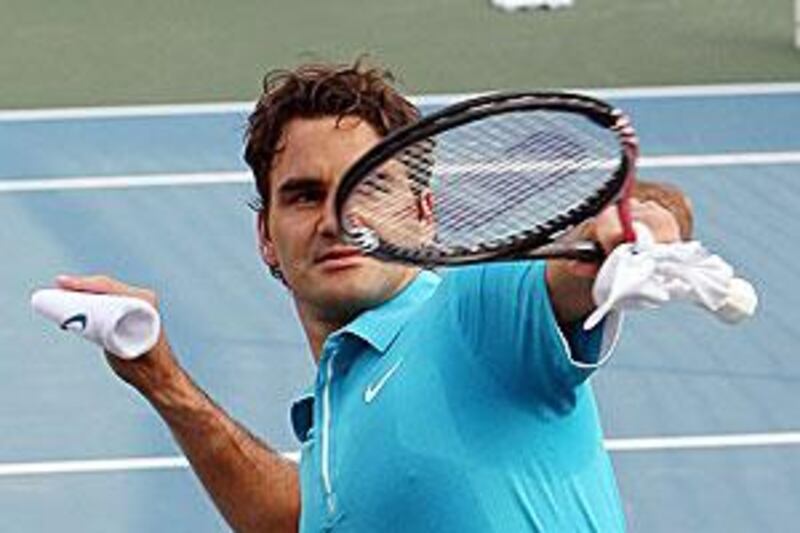Federer throws his arm band to the crowd at the Zayed Sports City in Abu Dhabi.