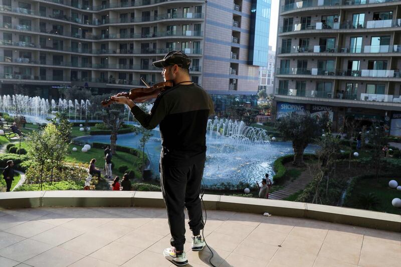 Iraqi Kurdish musician Nujin Hasan plays his violin to residents of his apartment block  in Erbil. AFP