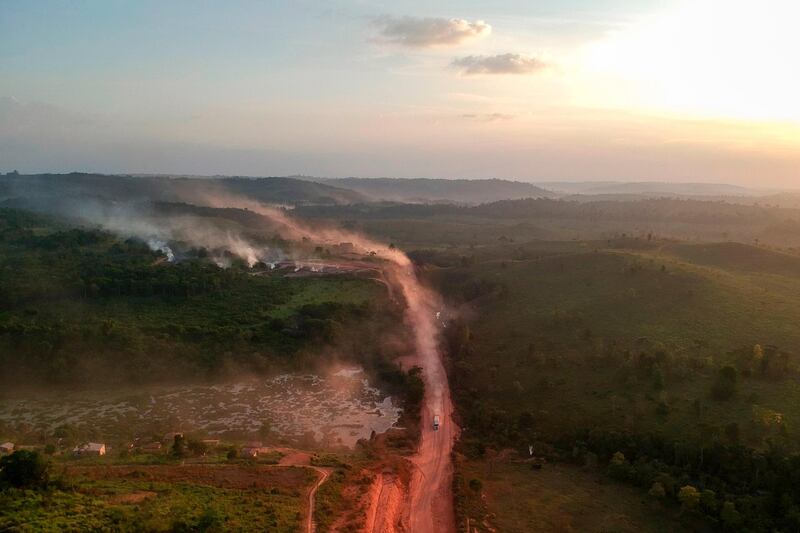 The red dust of the BR230 highway, known as "Transamazonica", mixes with fires at sunset in the agriculture town of Ruropolis, Para state, northen Brazil.  AFP