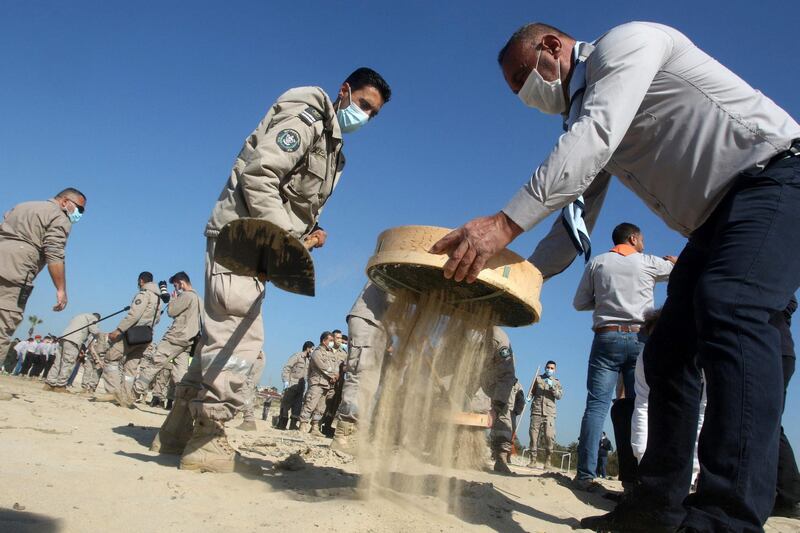 Volunteers from youth associations clean contamination from a beach in the southern Lebanese city of Tyre, following last week's offshore oil spill that hit the northern Israeli coastline and reached neighbouring Lebanon. AFP