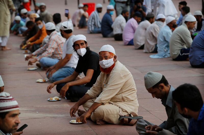 Muslims wearing masks as a precaution against the coronavirus wait to break fast on the first day of the holy month of Ramadan at the Jama Mosque, in New Delhi, India. AP Photo