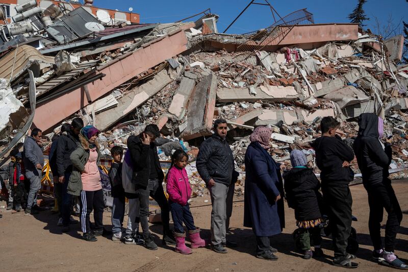 Quake survivors queue for food amid the rubble in Kahramanmaras. Reuters