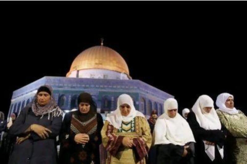 Palestinian Muslim worshippers pray outside the Dome of the Rock in the Al Aqsa Mosque compound in Jerusalem's Old City.