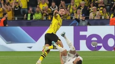Borussia's Niclas Fullkrug (up) celebrates after scoring for the 1-0 lead against PSG, as PSG's Lucas Hernandez (down) falls after their interaction during the UEFA Champions League semi final, 1st leg match between Borussia Dortmund and Paris Saint-Germain in Dortmund, Germany, 01 May 2024.   EPA / FRIEDEMANN VOGEL