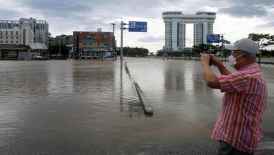 A man takes a photo of a submerged parking lot by Typhoon Maysak in Gangneung, South Korea, September 3, 2020.    Yonhap via REUTERS   ATTENTION EDITORS - THIS IMAGE HAS BEEN SUPPLIED BY A THIRD PARTY. SOUTH KOREA OUT. NO RESALES. NO ARCHIVE.