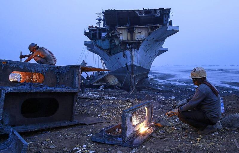 Indian workers dismantle a ship for scrap.  The country has become a prime destination for ageing European vessels as their country of registration is often changed at the end of their lifetime to sidestep EU regulations covering their demolition. Danish Siddiqui / Reuters