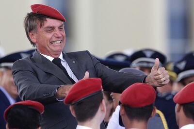 FILE - In this April 19, 2018 file photo, presidential hopeful, conservative Brazilian lawmaker Jair Bolsonaro flashes two thumbs up as he poses for a photo with cadets during a ceremony marking Army Day, in Brasilia, Brazil. For many Brazilians, Bolsonaro's candidacy in Sunday's Oct. 7 vote has long provoked fears because of his penchant for waxing nostalgic about the country's 1964-1985 dictatorship, along with his steady stream of derogatory comments about women, blacks, indigenous peoples and gays. (AP Photo/Eraldo Peres, File)