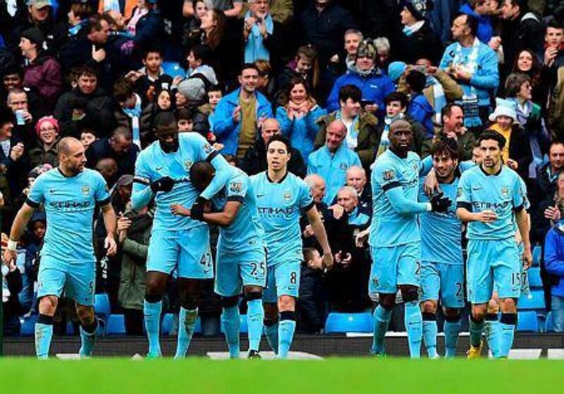 Manchester City's Spanish midfielder David Silva, second right, celebrates scoring the opening goal with teammates during the English Premier League football match against Crystal Palace at the Etihad Stadium in Manchester, north west England, on December 20, 2014. AFP PHOTO / PAUL ELLIS