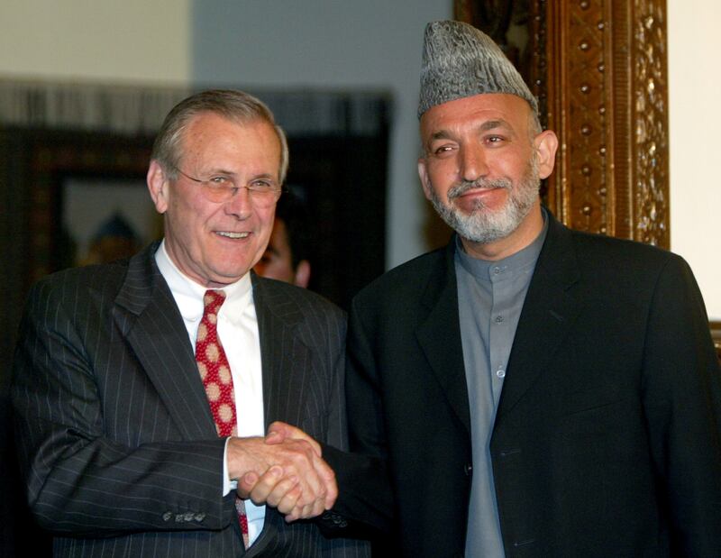 Donald Rumsfeld and Afghanistan president Hamid Karzai shake hands during a news conference in Kabul in 2003. Reuters