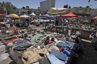 Palestinian browse stalls at a Friday market in Ramallah in June 2022. The Israel-Gaza war has had a devastating effect on the Palestinian economy. AFP