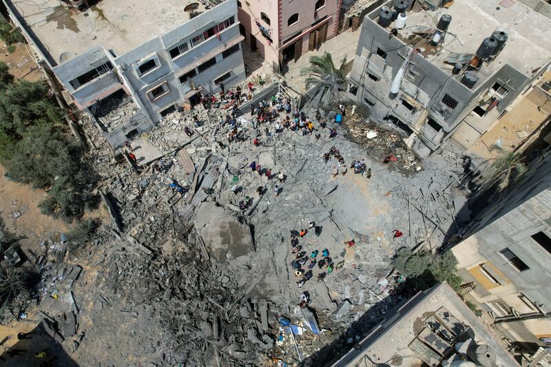 Palestinians inspect the remains of a house hit by an Israeli air strike. Reuters