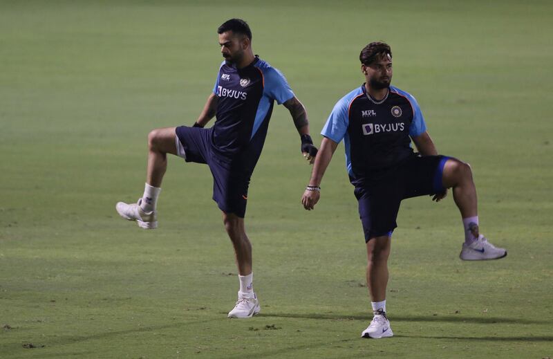 Indian cricket captain Virat Kohli, left, warms up during a training session a day ahead of their match against Pakistan. AP