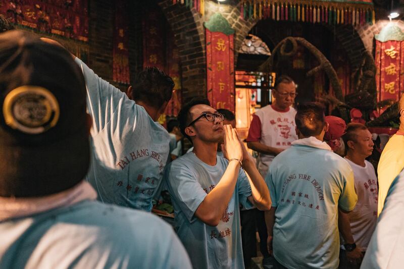 Members of the fire dragon dance team pray in the Lin Fa Temple at the Tai Hang Fire Dragon Dance Festival.