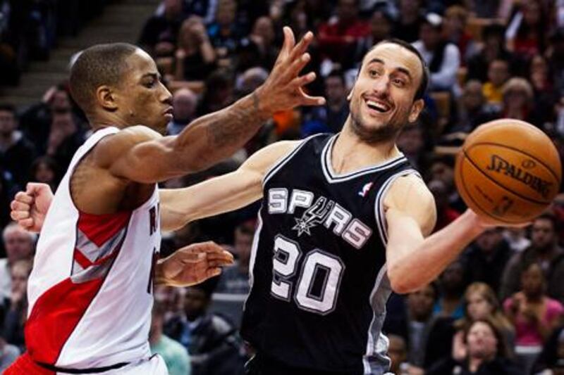 San Antonio Spurs' Manu Ginobili looks for a way round Toronto's DeMar DeRozan.