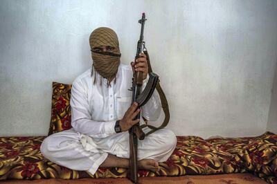 Qary Khalid, 25, poses with his gun in his living room. He joined the Taliban 10 years ago, after being educated in a madrassa - a religious school - in Peshawar, Pakistan. Stefanie Glinski for The National