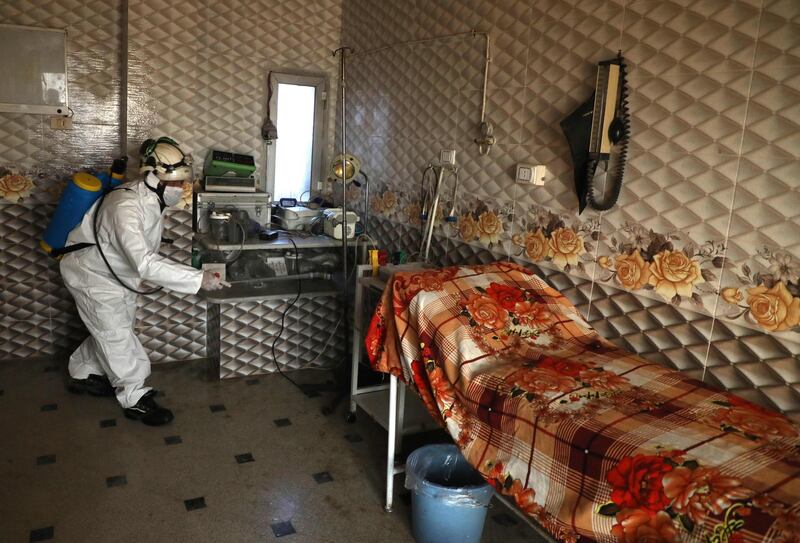 A member of the Syrian Civil Defence known as the "White Helmets" disinfects a hospital room in Dana, Syria, on March 22, 2020. AFP