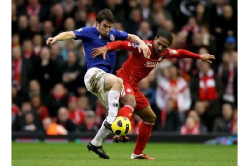 Everton’s Seamus Coleman, left, and Liverpool’s  Glen Johnson battle for the ball during yesterday’s 2-2 draw.