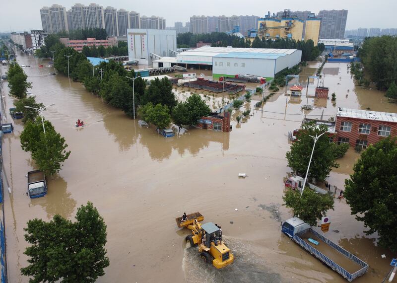 An aerial view shows rescue workers evacuating residents on a flooded road following heavy rainfall in Zhengzhou, Henan province, China.