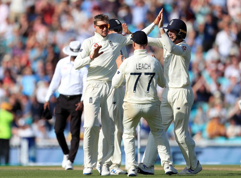 England captain Joe Root, left, celebrates taking the wicket of Australia's Mitchell Marsh. PA