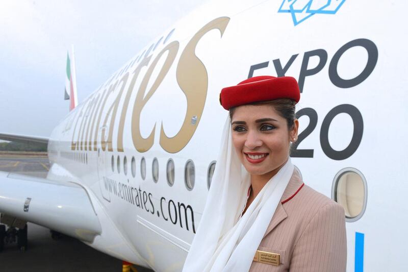 A flight attendant poses beside an Emirates Airbus A380 during a photo call at the India Aviation 2014 airshow in Hyderabad. Noah Seelam / AFP