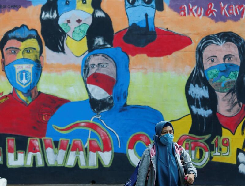 A woman walks past a mural promoting awareness of the coronavirus disease outbreak in Jakarta, Indonesia. Rueters