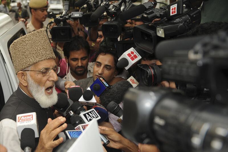 Chairman of Kashmir's hardline faction of All Parties Hurriyat Conference (APHC) Syed Ali Shah Geelani (C) talks with the media outside the Pakistan High Commision following a meeting with Pakistani Foreign Minister Hina Rabbani Khar in New Delhi on July 26, 2011. The foreign ministers of India and Pakistan will hold peace talks in New Delhi on July 27 overshadowed by triple bomb blasts in Mumbai and intense media interest in Islamabad's new top diplomat. They will be the first foreign minister-level discussions between the nuclear-armed neighbours and arch-rivals for a year. AFP PHOTO/Sajjad HUSSAIN

