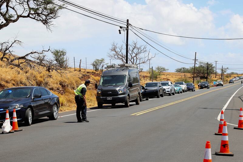 People wait on the side of the road to return to west Maui after evacuations were ordered. Reuters