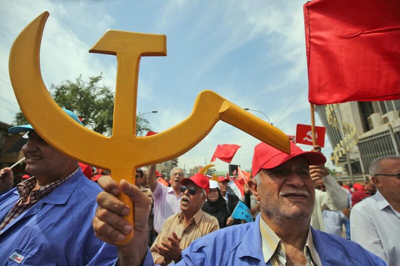 A supporter of the Iraqi Communist Party holds the communist symbol of the hammer and sickle during a march celebrating the International Workers Day in the Iraqi capital  Baghdad on May 1, 2018.  / AFP PHOTO / AHMAD AL-RUBAYE
