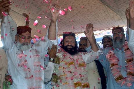 In this photo taken on July 15, 2011, Malik Ishaq, center, a leader of the banned Sunni Muslim group Lashkar-e-Jhangvi, and his colleagues raise hands to response their supporters who greeted him with rose-petals upon his arrival at hometown after his release from jail, in Rahim Yar Khan, Pakistan. Fourteen years in prison had not tempered one of Pakistan's most feared extremist leaders: Within days of his release, Ishaq was preaching murderous hatred toward Shiites infront of cheering crowds, energizing a militant network whose members have joined al-Qaida for terror strikes. (AP Photo/Khalid Tanveer)                                  *** Local Caption ***  Pakistan Militant Bad Deal.JPEG-04cff.jpg