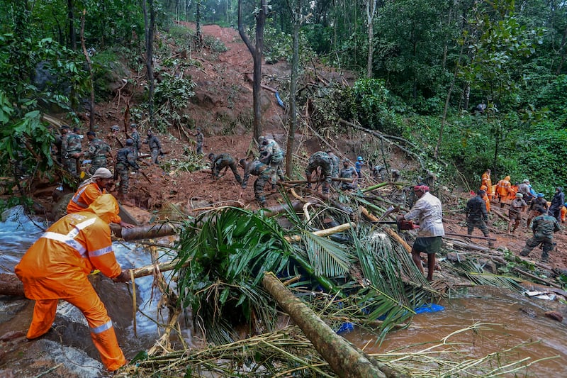 Rescuers search for bodies in Koottickal, southern Kerala. AP