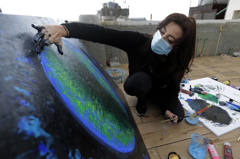 Lebanese Artist Hayat Nazer paints on the roof of her family's apartment in Tripoli.   AFP