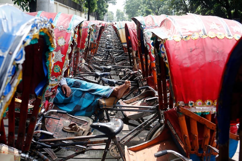 A Bangladeshi labourer sleeps on the pushcart at Babu Bazar the wholesale rice market in Dhaka.  EPA