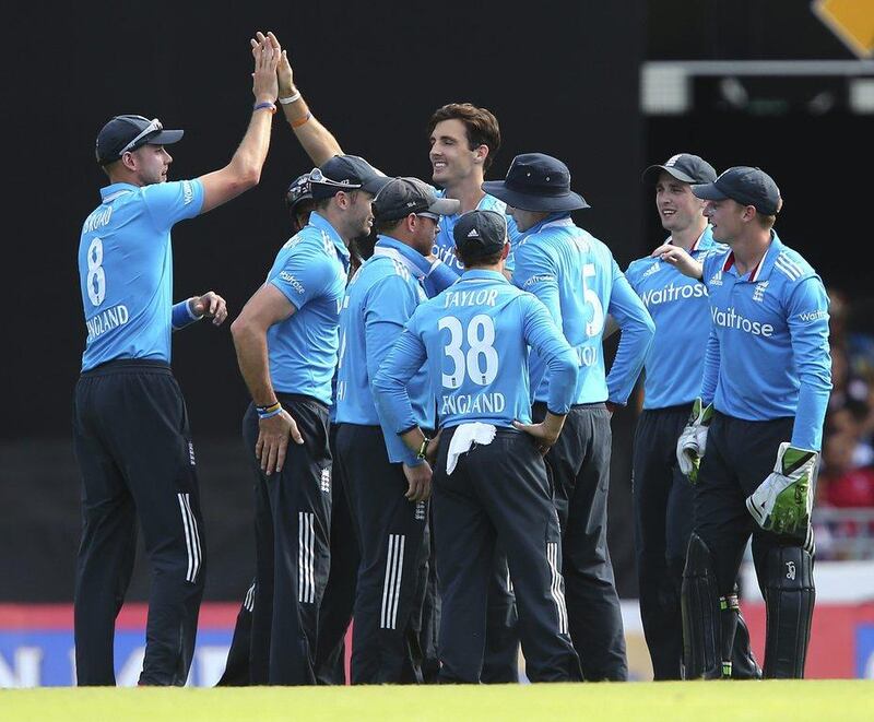 Steven Finn, centre, celebrates with his teammates after he got the wicket of India's MS Dhoni during England's tri-series win in Brisbane. Tertius Pickard/AFP