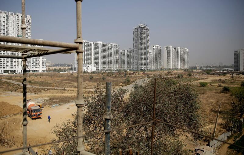 An Indian worker walks near a concrete mixer truck at a proposed site for the Trump Towers in Gurgaon, a suburb of New Delhi, India. Altaf Qadri / AP Photo